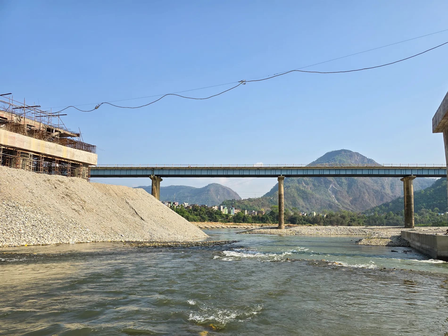 Steel bridge spanning a river in western Nepal